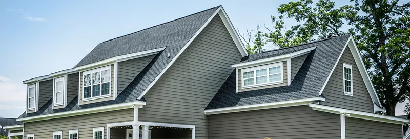 Two-story home with dormers and a shingle roof