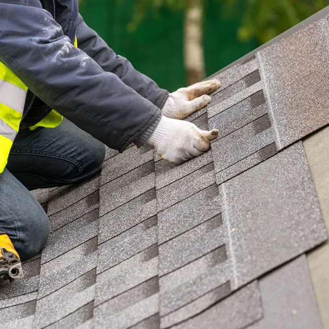 Roofer setting new architectural shingles