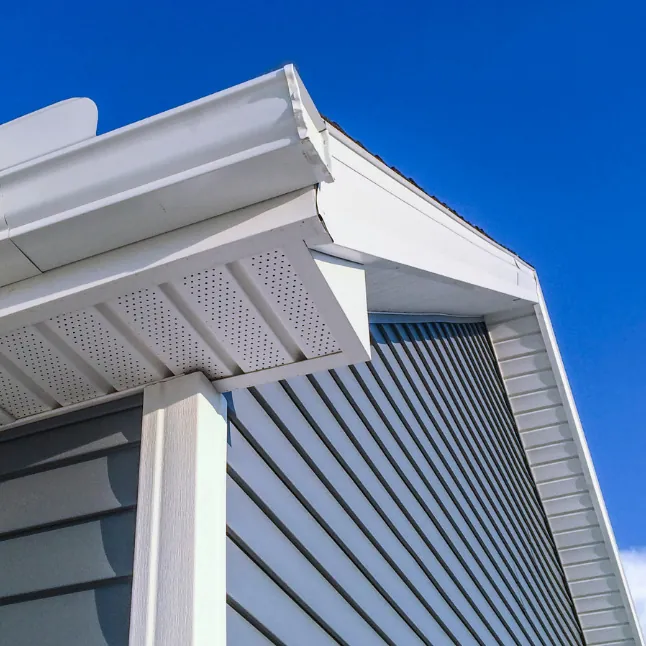 Vented soffit and fascia trim against a blue sky